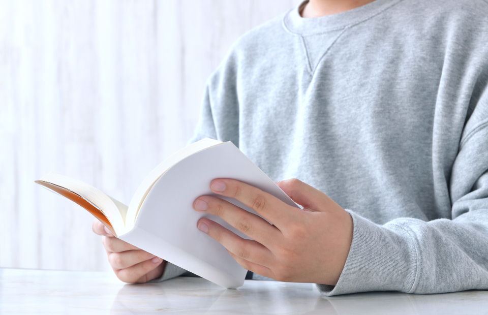 クリップボードにメモを取っている男性の手元のクローズアップ